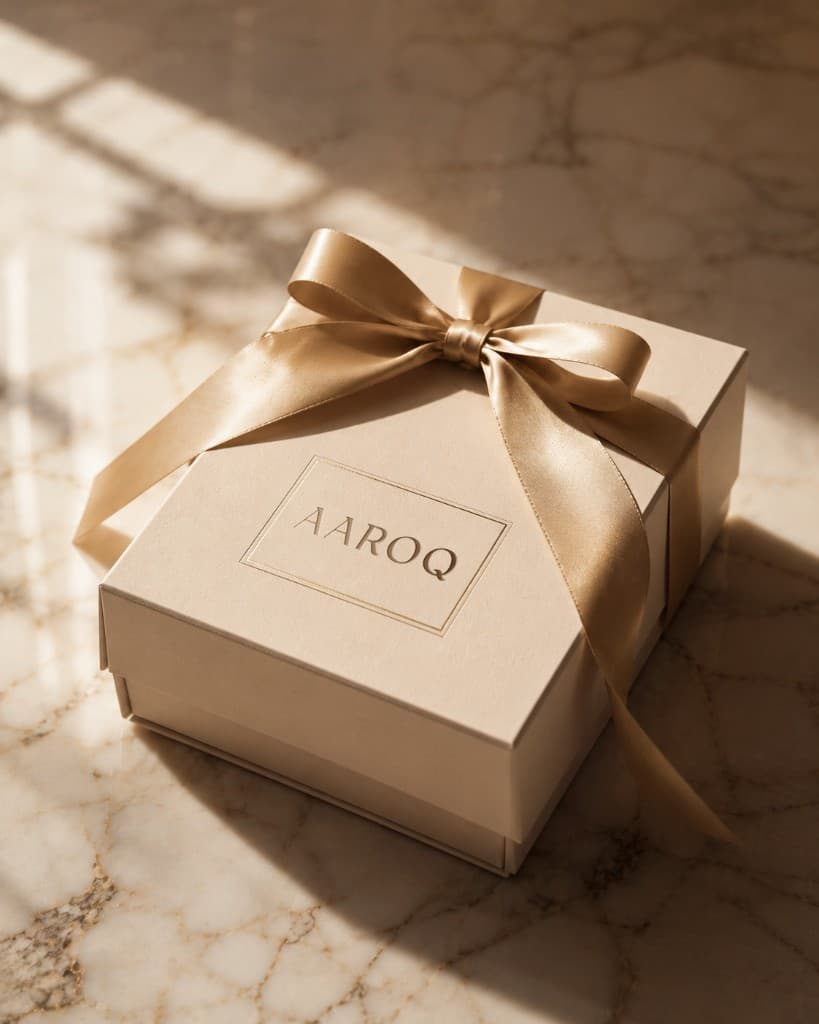 AAROQ debossed on a cream gift box with champagne ribbon